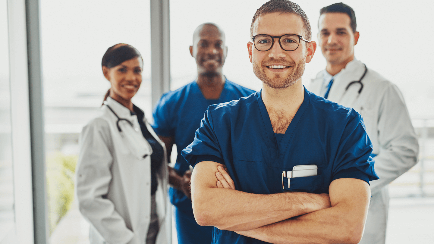 Ärzteteam in medizinischer Kleidung lächelt und vermittelt Vertrauen.