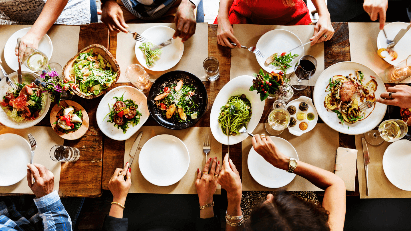 Mehrere Personen genießen gemeinsam eine Mahlzeit – Vielfalt an Gerichten.